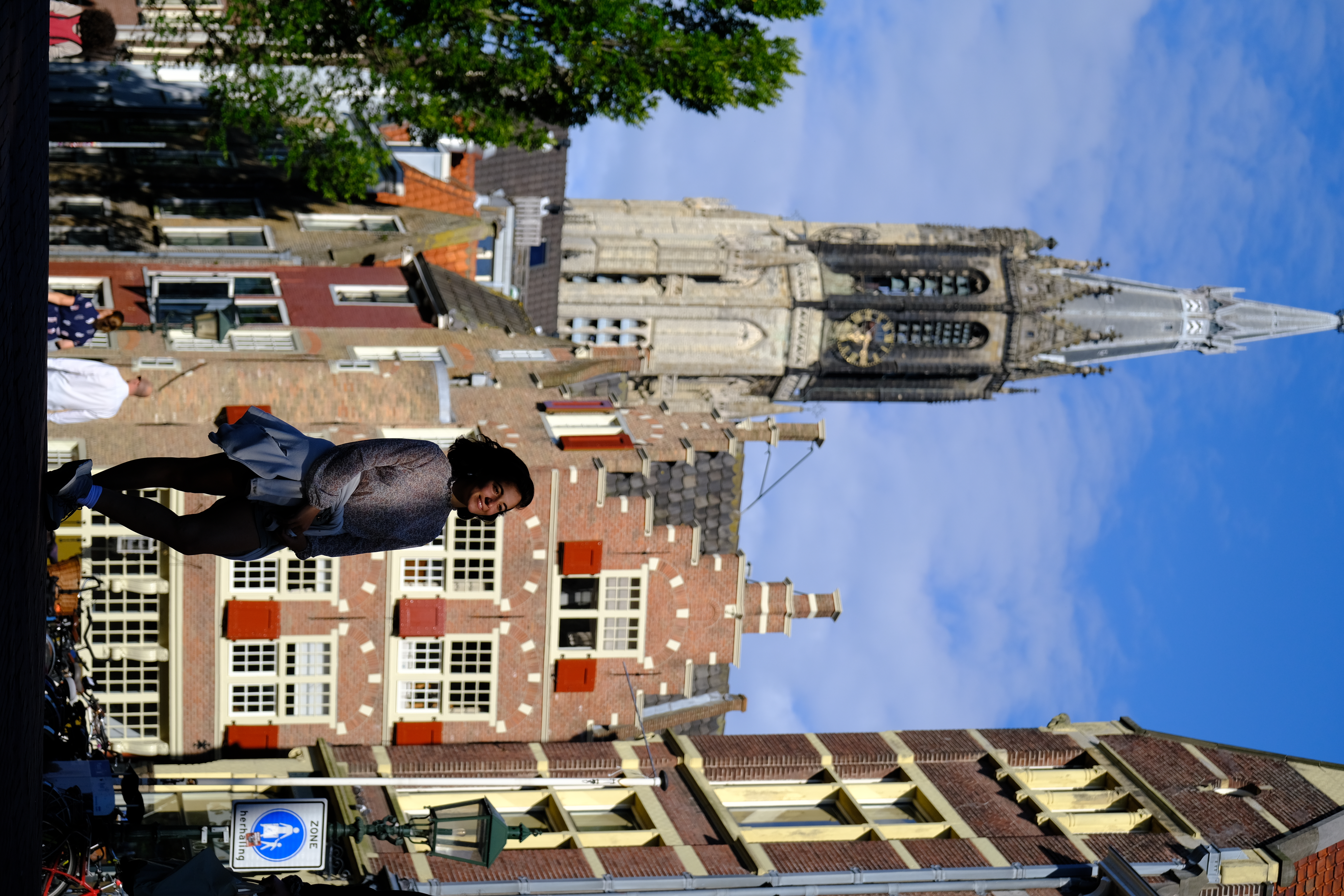 Full-figure lifestyle moment with church tower backdrop, Delft